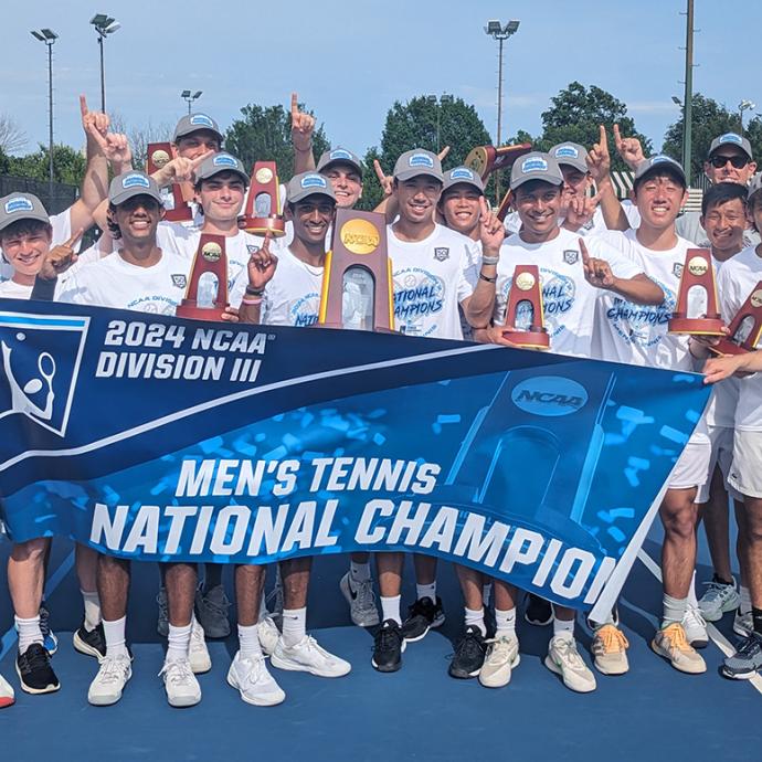 UChicago men's tennis team pose with the national championship banner after winning the NCAA Division III title