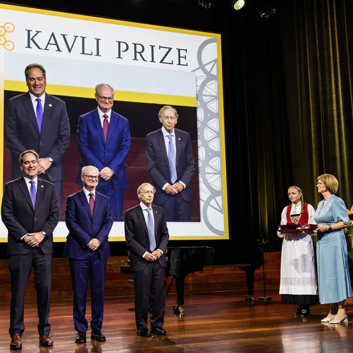 Photo of 3 scientists on a stage with The Kavli Prize backdrop behind