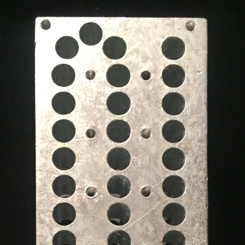 The quantum flute looks like a metallic rectangle with many holes on top.