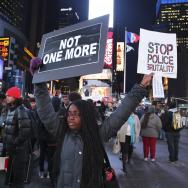 A protestor holds up signs during a demonstration against police brutality in New York City's Times Square.