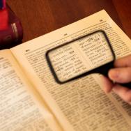 Magnifying glass looking at dictionary