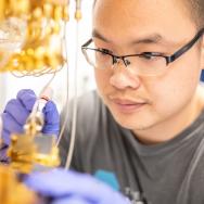 Researcher works in gloves on metallic quantum assembly