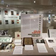 Exhibition case displaying documents, photos, and items related to the Color Curtain Processing Project—a survey initiative of the BMRC. 