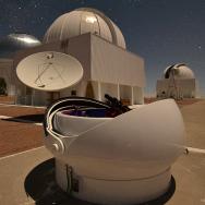 Photo shot from the ground level of three domes against a night sky