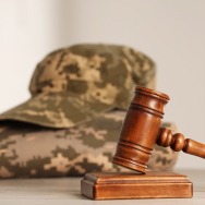 Gavel and military uniform on wooden table