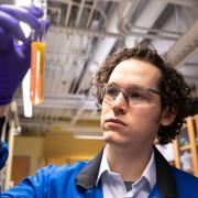 A UChicago chemist examines an orange liquid